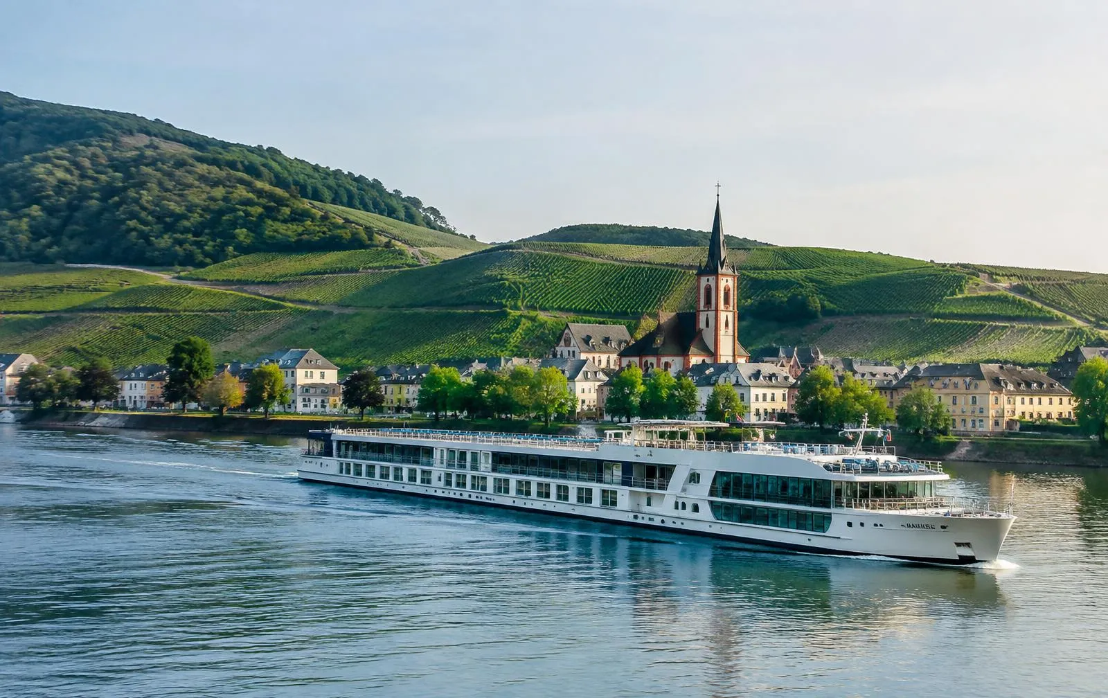 A river cruise ship sailing past a European village with a church spire and vineyards